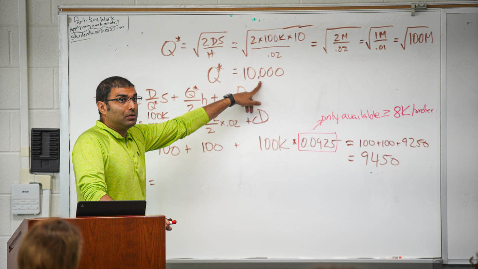 Faculty standing at a white board teaching.